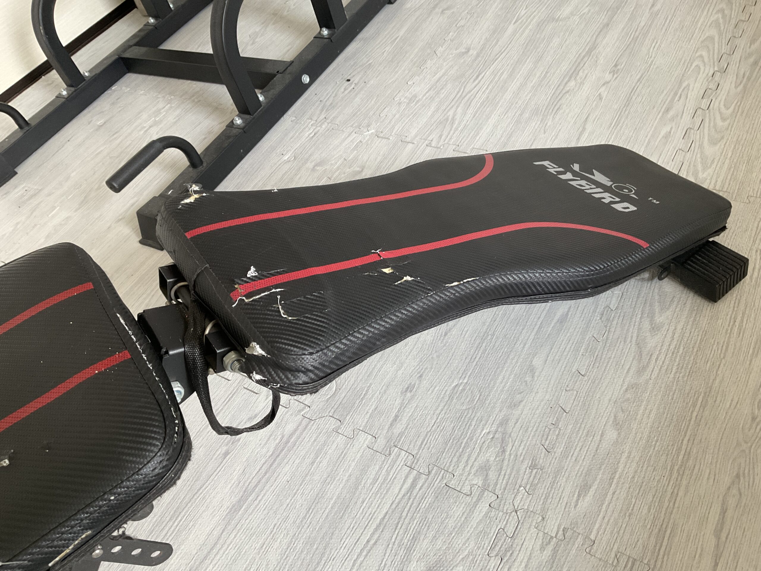 デクライン状態にしたFLYBIRDのトレーニングベンチ。シート全体にわたる傷やスレなどの使用感が確認できる状態。
