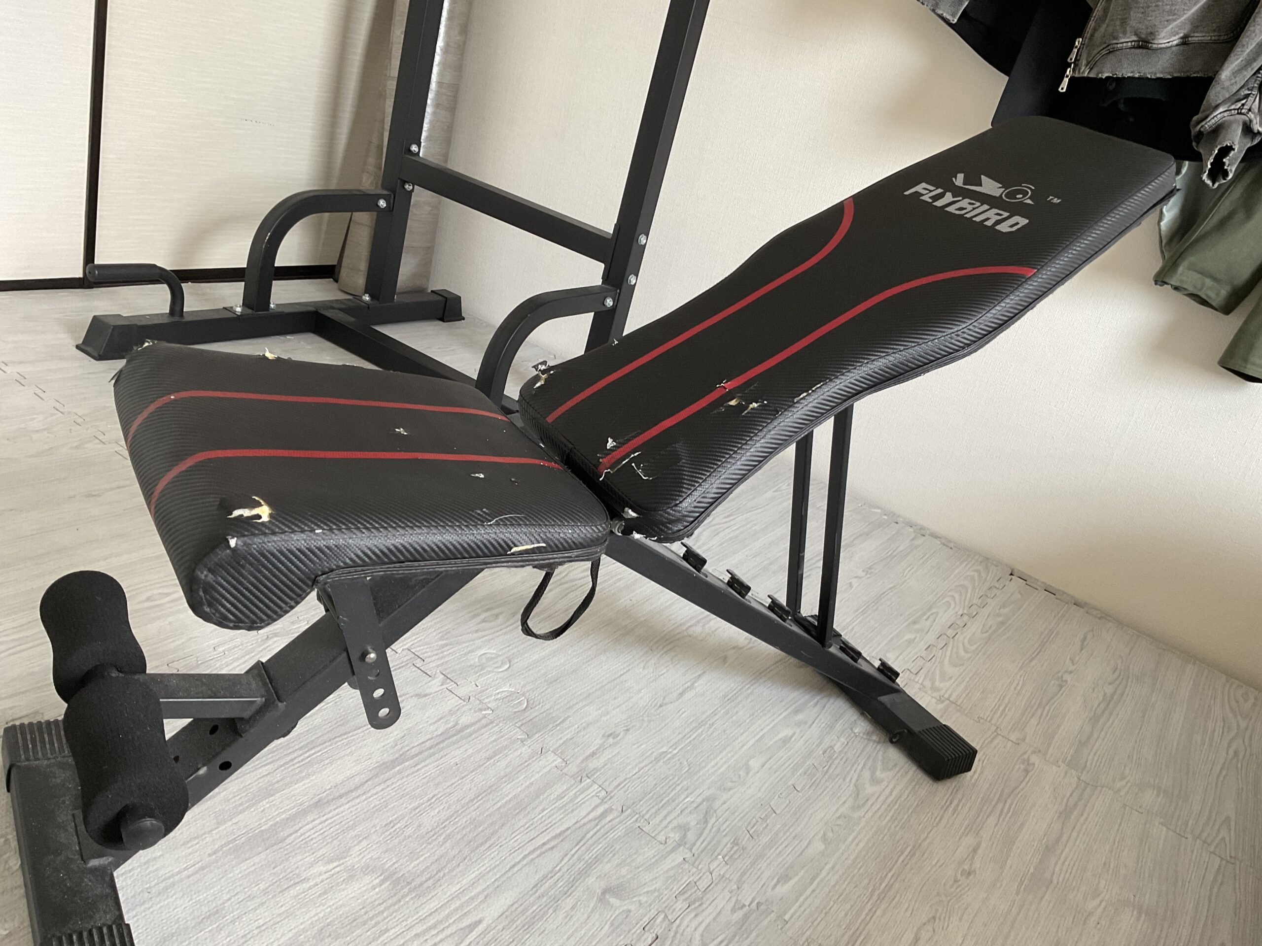 インクライン状態にしたFLYBIRD(フライバード)のトレーニングベンチ全体像。シート表面に複数の破れや傷がある状態。