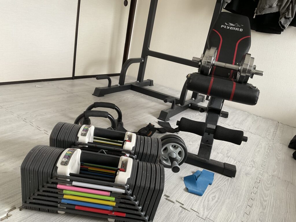 可変式ダンベル、インクラインベンチ、懸垂マシン、腹筋ローラーなど自宅に揃えた筋トレ器具一式